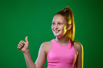 teenager showing Ok gesture on green background.