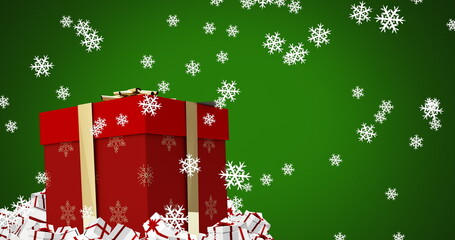 Digital image of snowflakes falling over christmas gift box against green background