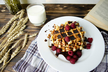 Viennese waffles poured with chocolate and berries. homemade fresh baked goods