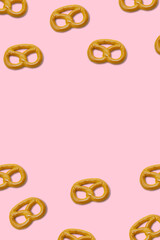 cookies pretzels on pink background top view copy space