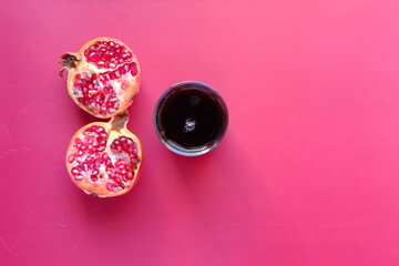 glass on pomegranate juice on red background .