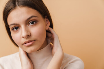 Young woman touching her face and looking at camera