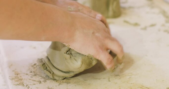 Pottery artist preparing clay for molding in ceramic studio.