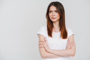 Young ginger woman in t-shirt frowning and looking aside