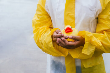 Girl with toy duck in rainy weather