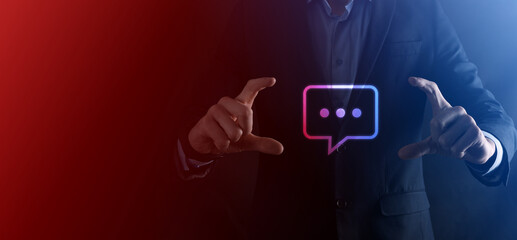 Businessman holding a message icon, bubble talk notification sign in his hands. Chat icon, sms icon, comments icon, speech bubbles
