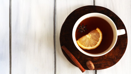 .Horizontal image of white cup of tea with lemon cinnamon and anise