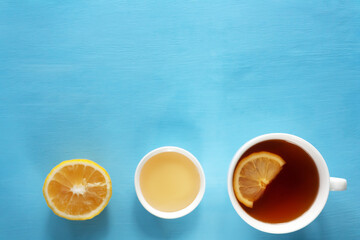Herbal tea with honey and lemon on blue background healthy food concept. Minimalistic flat lay