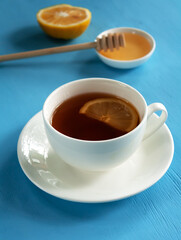 Antioxidant healthy black tea with lemon and honey on a blue background. Alternative medicine concept