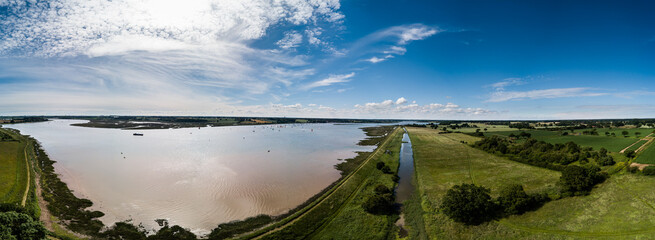 Aerial panoramic of the River Deben in Suffolk, there is a group of people racing sailing boats in the distance