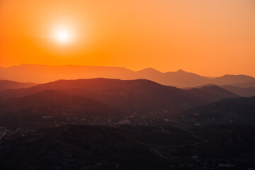 Silhouettes of mountains at dawn or sunset. Beautiful natural orange landscape