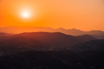 Fototapeten Silhouettes of mountains at dawn or sunset. Beautiful natural orange landscape © KseniaJoyg