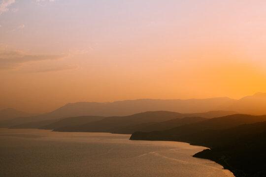 Silhouettes Of Mountains At Dawn Or Sunset. Beautiful Natural Orange Landscape