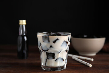 Glass of milk with grass jelly on wooden table