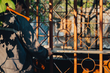 Portrait of concentrated mature builder placing spirit level. Handyman working with building level indoors. Professional tools to check measure level of metal construction at Renovation in backyard