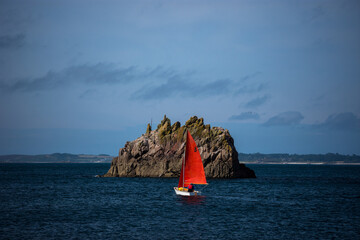 Sailboat with red sail on the sea