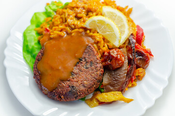 Meat free burger and long grain rice with red peppers, tomatoes and jalapeno chillies