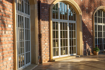 A fragment of a brick wall of a house with large windows.