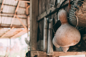 Dried gourds and utensils hang beside the wooden wall.
