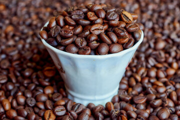 Fototapeta premium A cup full of freshly roasted coffee beans.