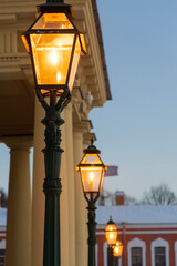 Evening burning lanterns stylized as gas lamps in the evening twilight