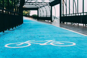 Bicycle symbols on the floor of a bicycle lane painted in blue.