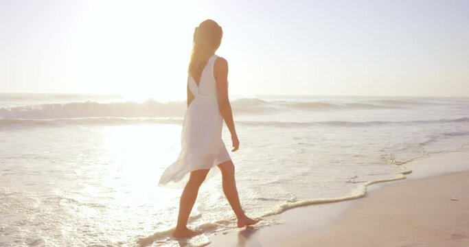 beautiful woman wearing white dress walking on beach at sunset in slow motion RED DRAGON
