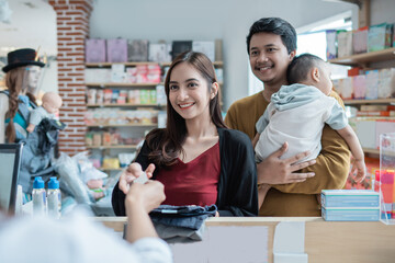 family making a payment at the baby shop using credit card at the cashier