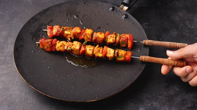 Woman cooking Tandoori Paneer tikka on tawa pan skewers 4K footage video grilled cottage cheese tandoor Indian appetizer Delhi Rajasthan India. Indian vegetarian starter side dish roti Chapati naan