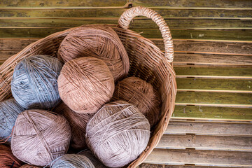 Cotton thread rolls in rattan basket preparing for cloth weaving.