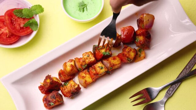 Woman eating Tandoori Paneer tikka green chutney 4K footage video tawa pan fried grilled cottage cheese tandoor Indian appetizer Delhi Rajasthan India vegetarian starter side dish roti Chapati naan