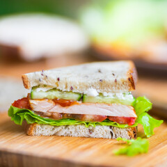 Toast sandwich with chicken, cheese, tomato, cucumber, and lettuce.