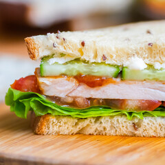 Toast sandwich with chicken, cheese, tomato, cucumber, and lettuce.