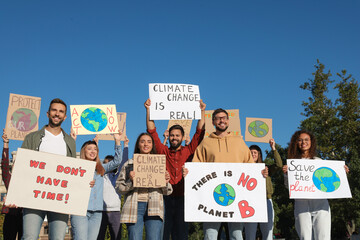 Group of people with posters protesting against climate change outdoors