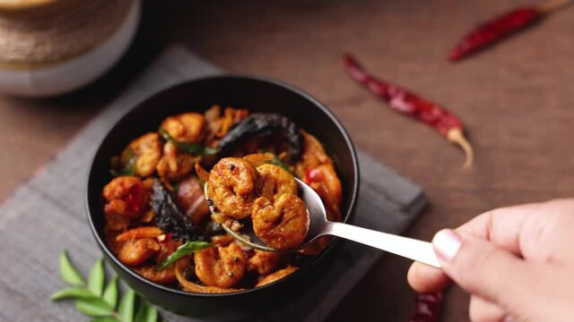 Serving Shrimp masala fish curry Chemmeen curry tiger Prawns balchao Curry 4K video footage. Spicy Kerala fish curry Indian seafood non veg food side dish rice appam Goan Tamil Nadu Bengal Sri Lankan 