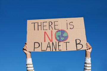 Young woman with poster protesting against climate change outdoors, closeup - obrazy, fototapety, plakaty