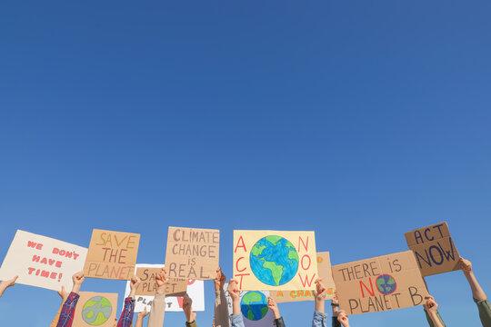 Group of people with posters protesting against climate change outdoors, closeup