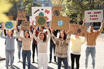 Group of people with posters protesting against climate change on city street
