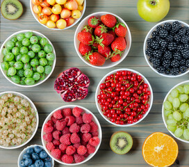 Mix of fresh berries, nuts and fruits. Wooden background.