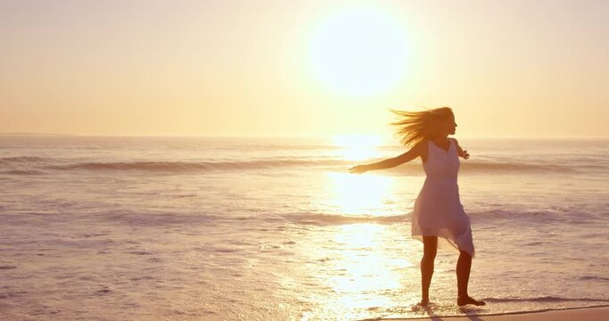 Free happy woman spinning arms outstretched enjoying nature dancing on beach at sunset slow motion RED DRAGON