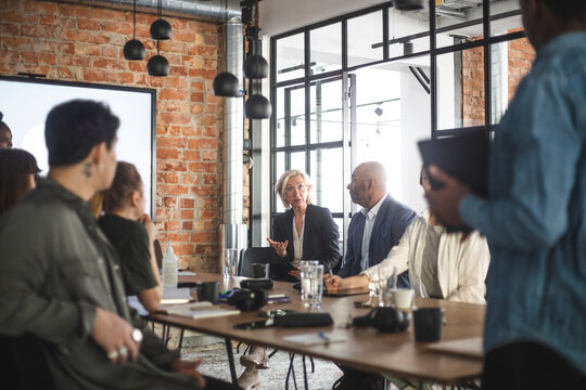 Female Investor Discussing With Hackers During Meeting At Startup Company