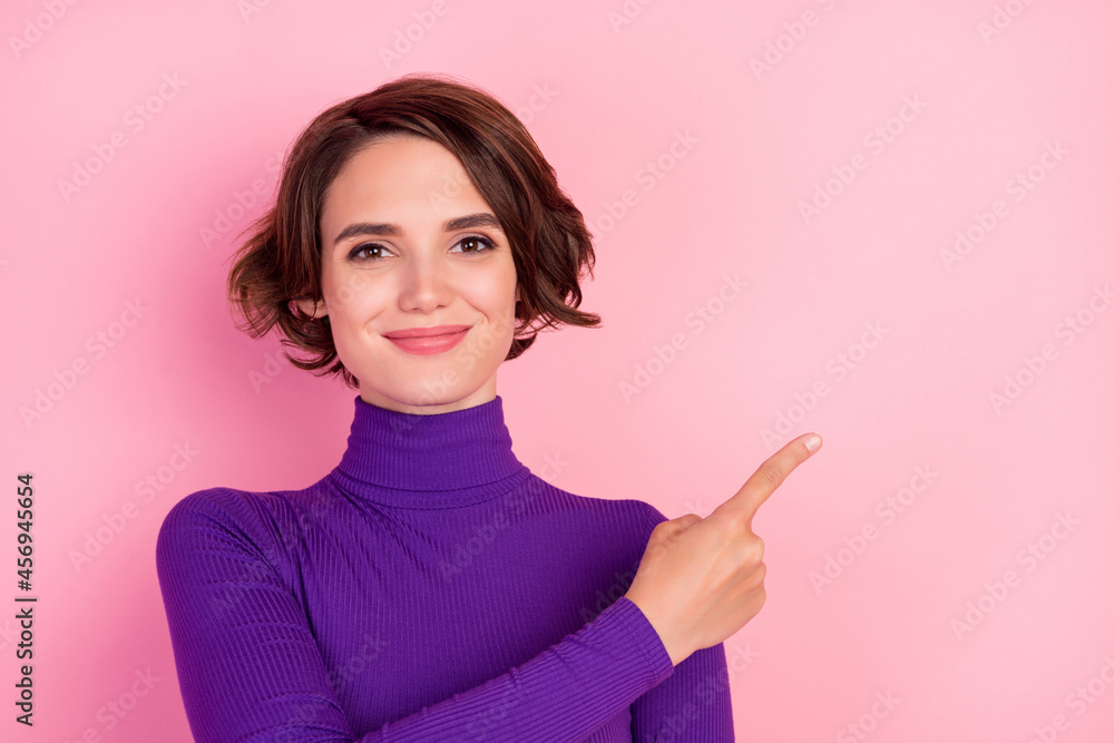 Sticker Photo of optimistic brunette young lady point empty space wear violet sweater isolated on pink color background