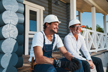 Happy builders are relaxing on porch stairs