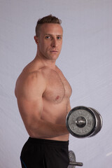 Fototapeta na wymiar Strong Shirtless man lifting weights