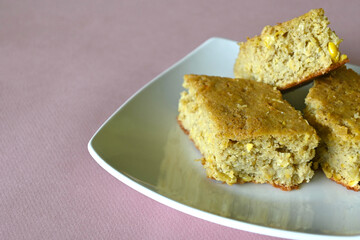 Traditional mexican pan de elote (cornbread) on pink background with copy space