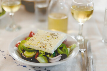 Traditional Greek Salad with feta cheese. Dinner in Greek tavern.