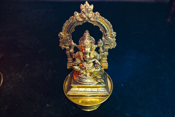 Golden statue of Lord Ganeshji placed in black floor