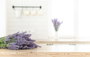 A bouquet of lavender in the interior of a stylish kitchen. Vertical frame mockup on a wooden table.