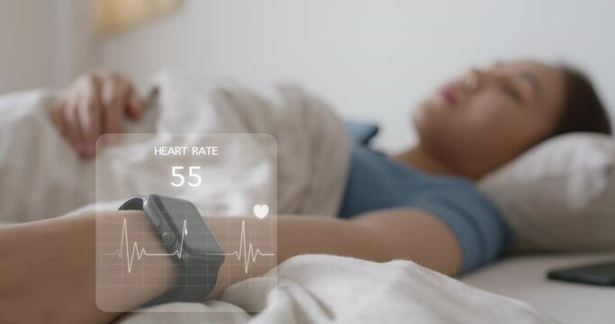 Asia teen woman wear smartwatch for sugar tracker, blood pressure tracking, resting sleep rate on arm IoT tech collect data app device relax body on cozy bed in future life at home.