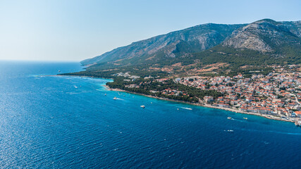 Fototapeta premium Drone shot on the Croatian resort island of Hvar in the Adriatic Sea. View from the drone to the port. Boats and ships on the shores of the Adriatic Sea in Croatia. Mountains on the island of Hvar. 